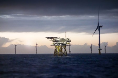 Offshore platform substation and wind farm in sunset