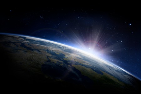 Sunlight ascending over Earth in outer space