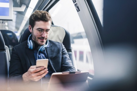 Man working on tablet in train