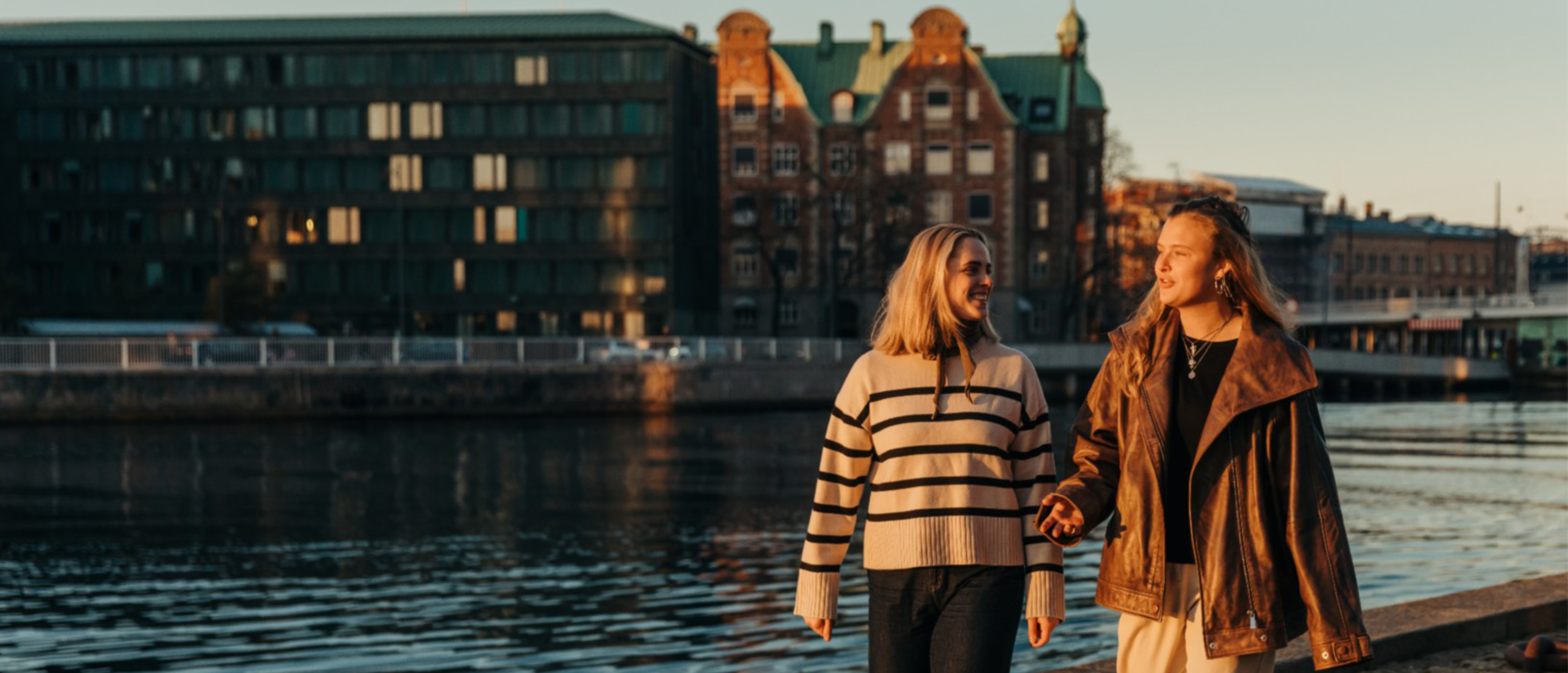 Two women walking along the side of a river