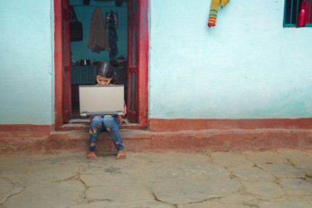 Indian village girl operating laptop at home