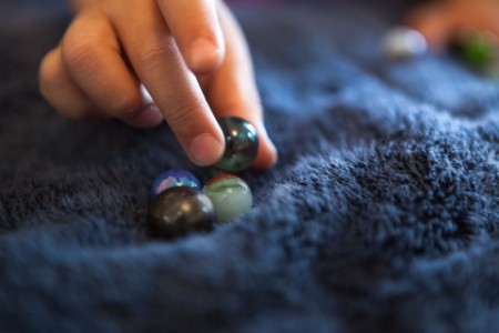 Kid playing with marble balls