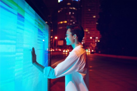 Young businessman using touch screen on the street