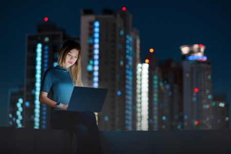 Woman using laptop on the rooftop of building