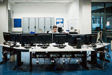 Engineer working behind computers control room