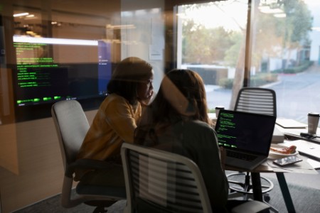 Naispuoliset ohjelmoijat työskentelevät kannettavilla tietokoneilla