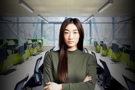 Portrait of young woman with arms crossed in an office