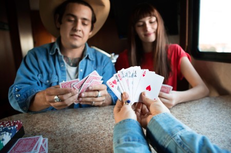 Frau hält Karten in der Hand bei Spiel in Wohnwagen