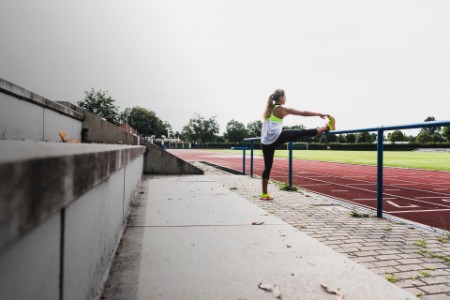 Woman stretching in a track and field stadium