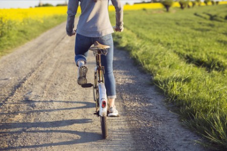 Woman cycling on country road