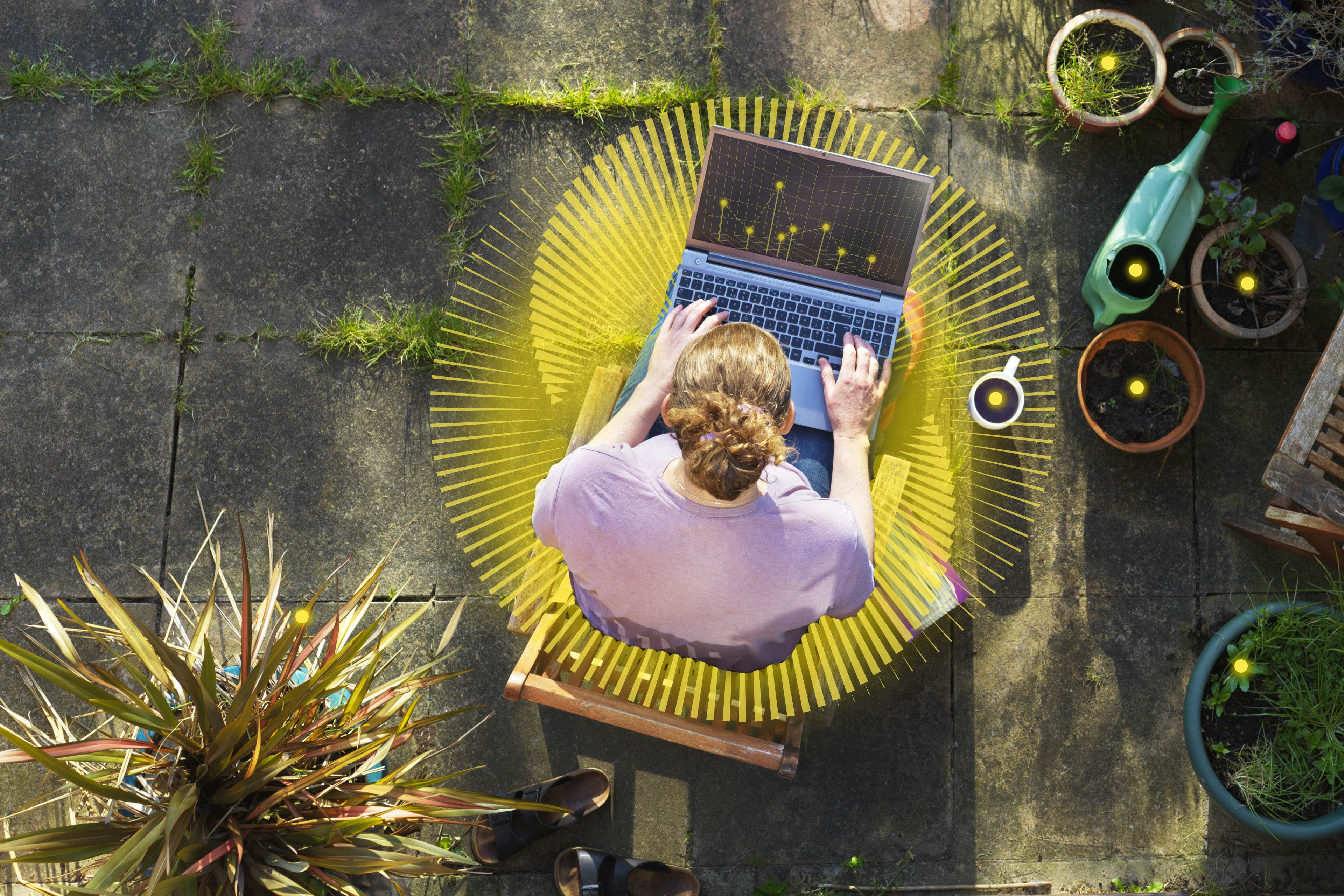 Elevated view of a woman working from home in her garden using a laptop computer