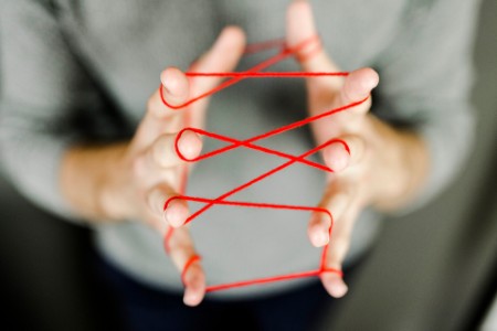 Close-up of man holding string aking a cats-cradle