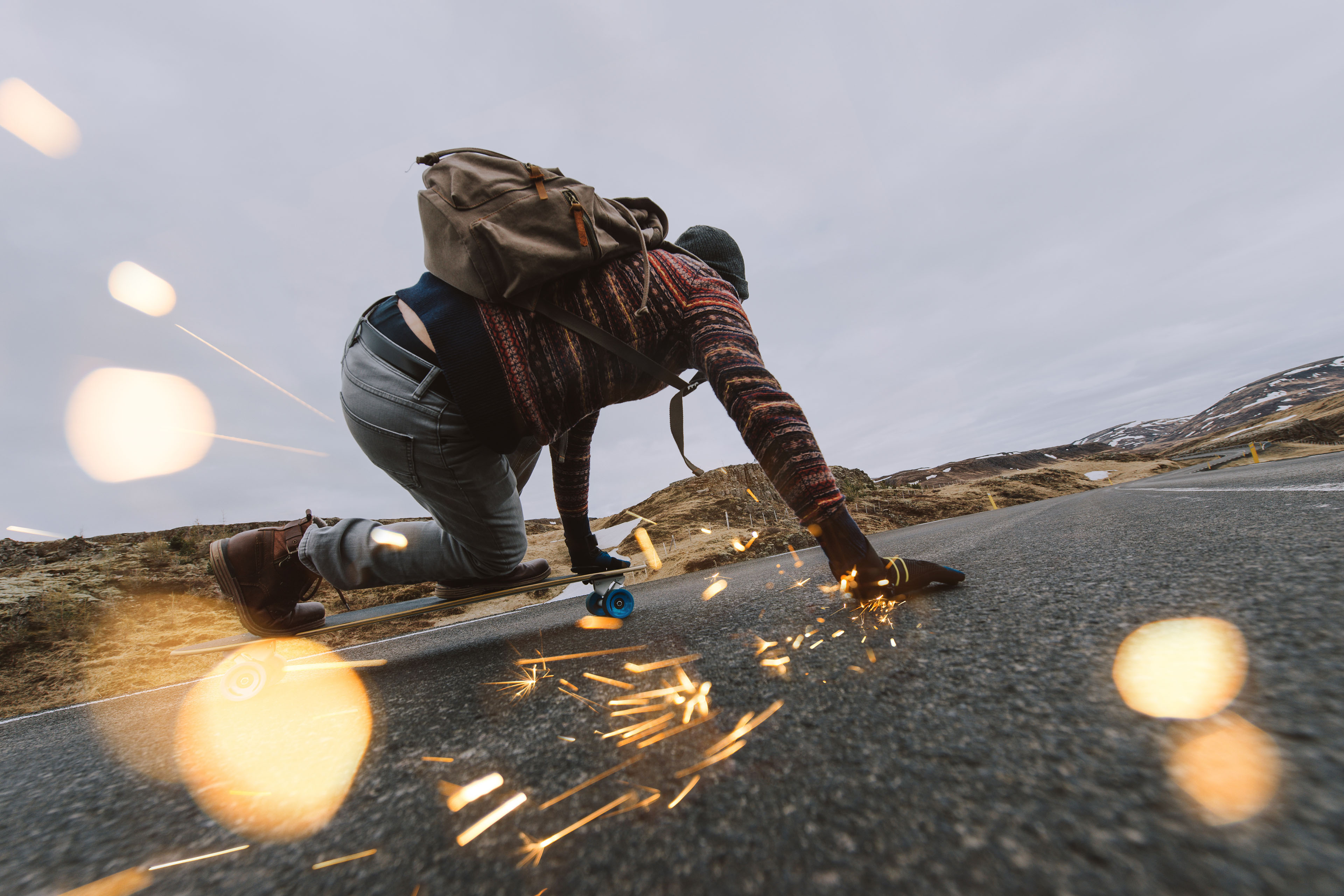 Longboarder creating sparks on road on downhill run