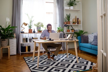 自宅でノートパソコンを使用して仕事をする男性