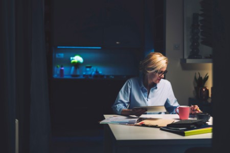 Mujer de negocios que usa la tecnología mientras está sentada en un escritorio en la oficina en su casa
