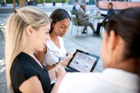 Mujeres empresarias revisando datos en una tablet