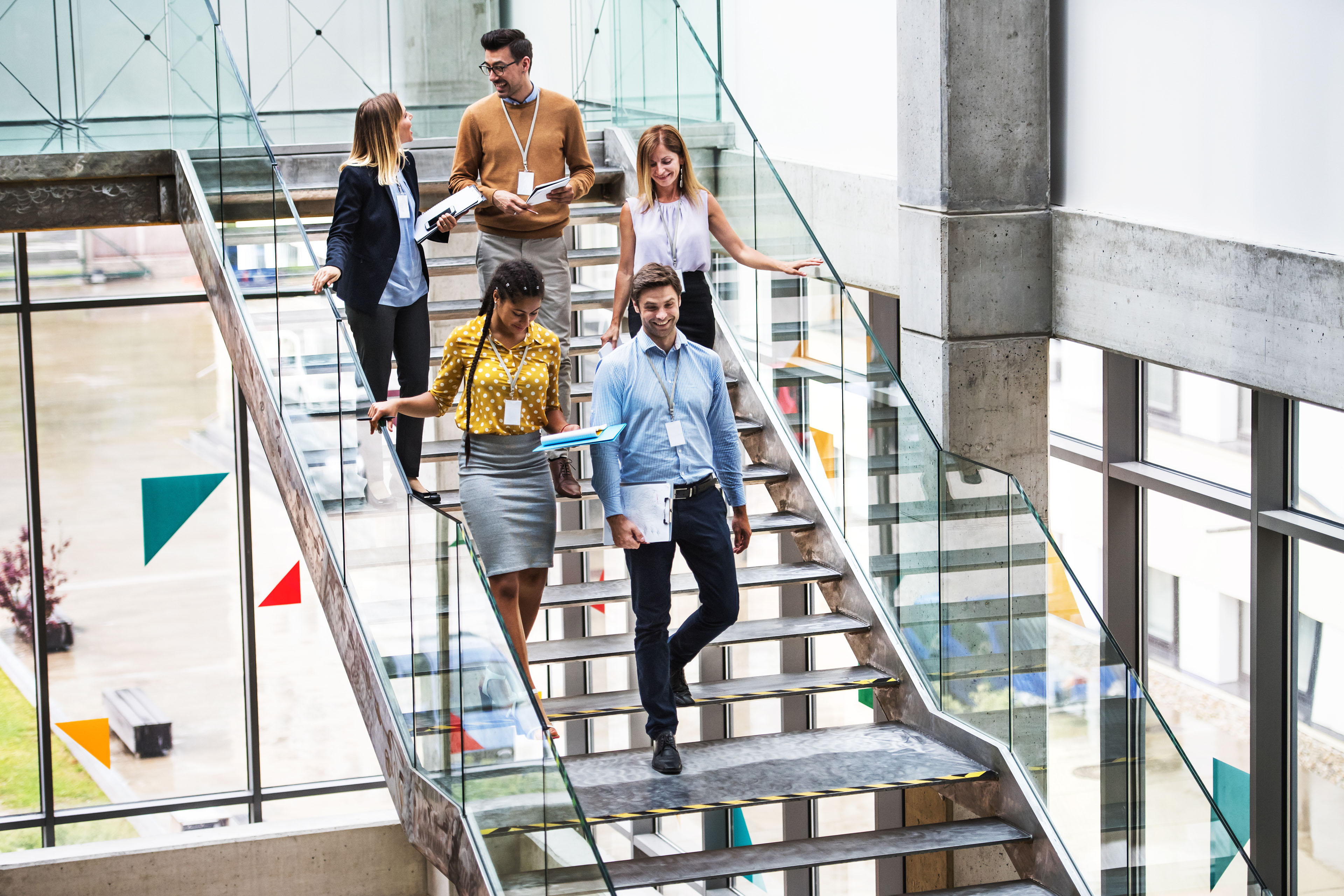 https://assets.ey.com/content/dam/ey-sites/ey-com/en_gl/topics/assurance/ey-group-businesspeople-walking-down-stairs-modern-building-talking-background.jpg