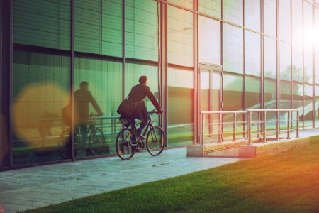 A an riding his bicycle beside the modern office building