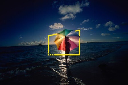 Woman standing on beach with umbrella on caribbean island