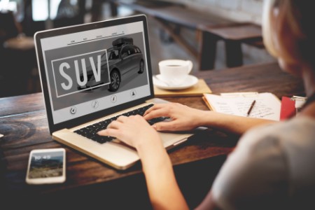 Person shopping for a suv online on a laptop