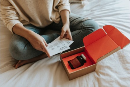Woman opening box on bed