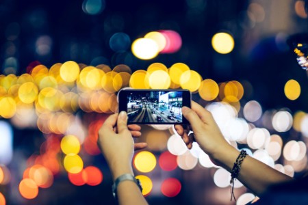 Woman photographing night scene smartphone