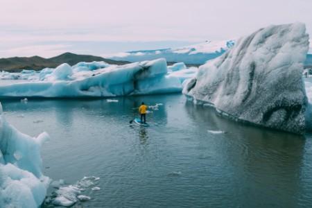 Aerial view of stand up paddle boarder paddling in glacier lagoon