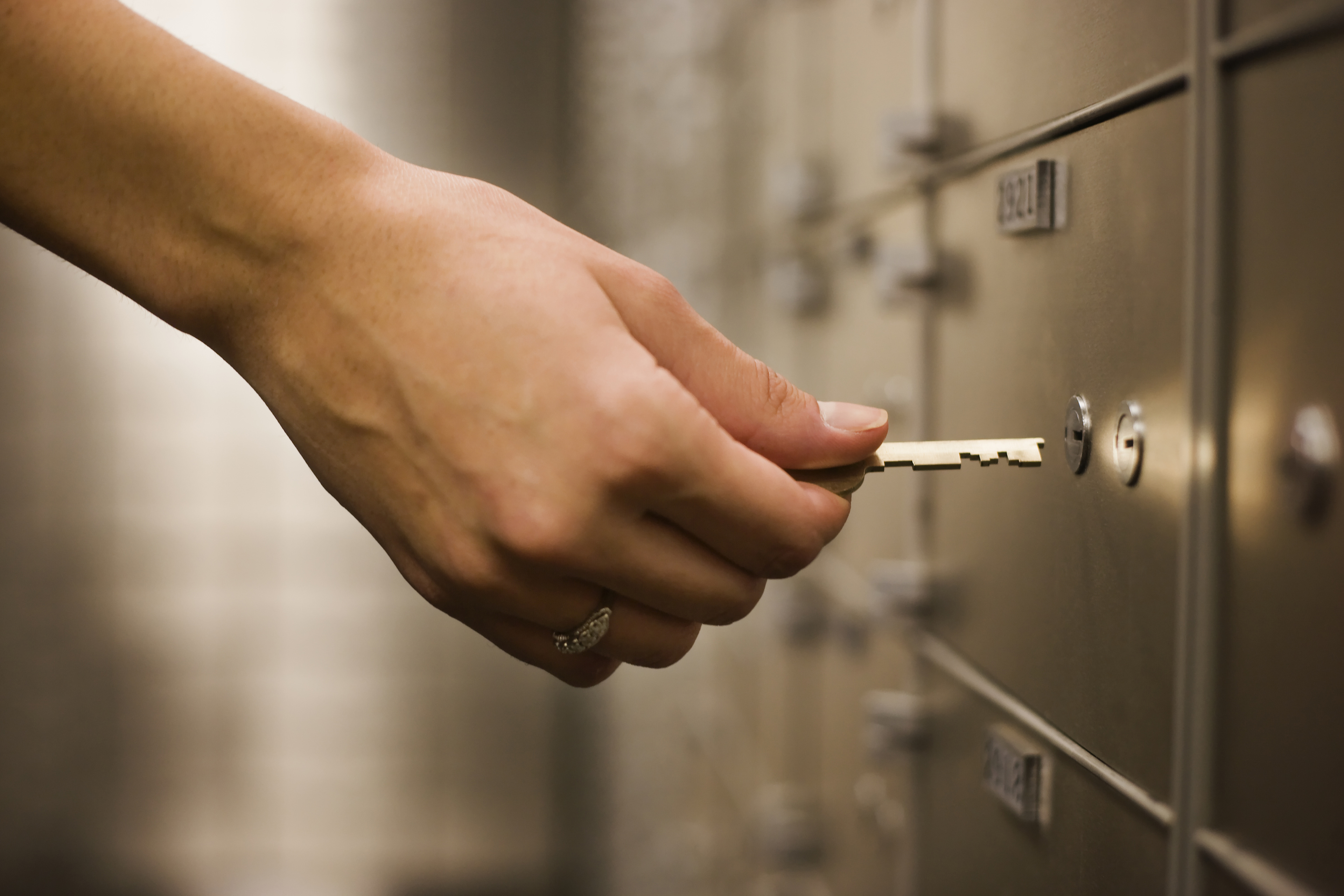 hand holding key safety deposit box