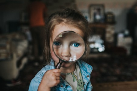 A little girl holding a magnifying glass