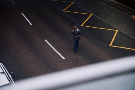 Man watches for traffic as he crosses the street