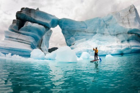 Man stand up paddle board hole melted iceberg Alaska