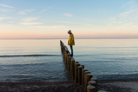 Woman standing post beach sunset