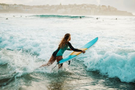 Woman surfer jumps wave