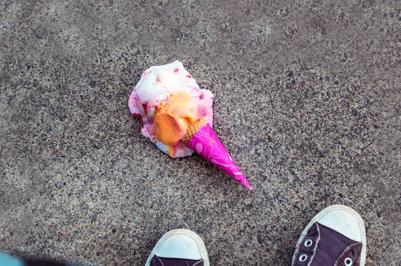 歩道に落ちたピンク色のアイスクリーム  