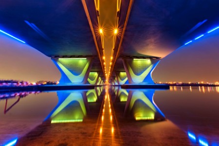 Illuminated underside of bridge at night