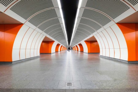 Imagen de una estación de subterráneo con persona que camina en el centro