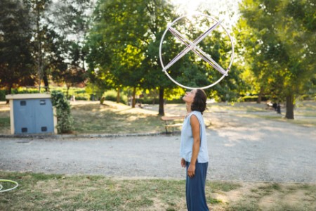 woman balancing hula hoop on her head at the park meta image