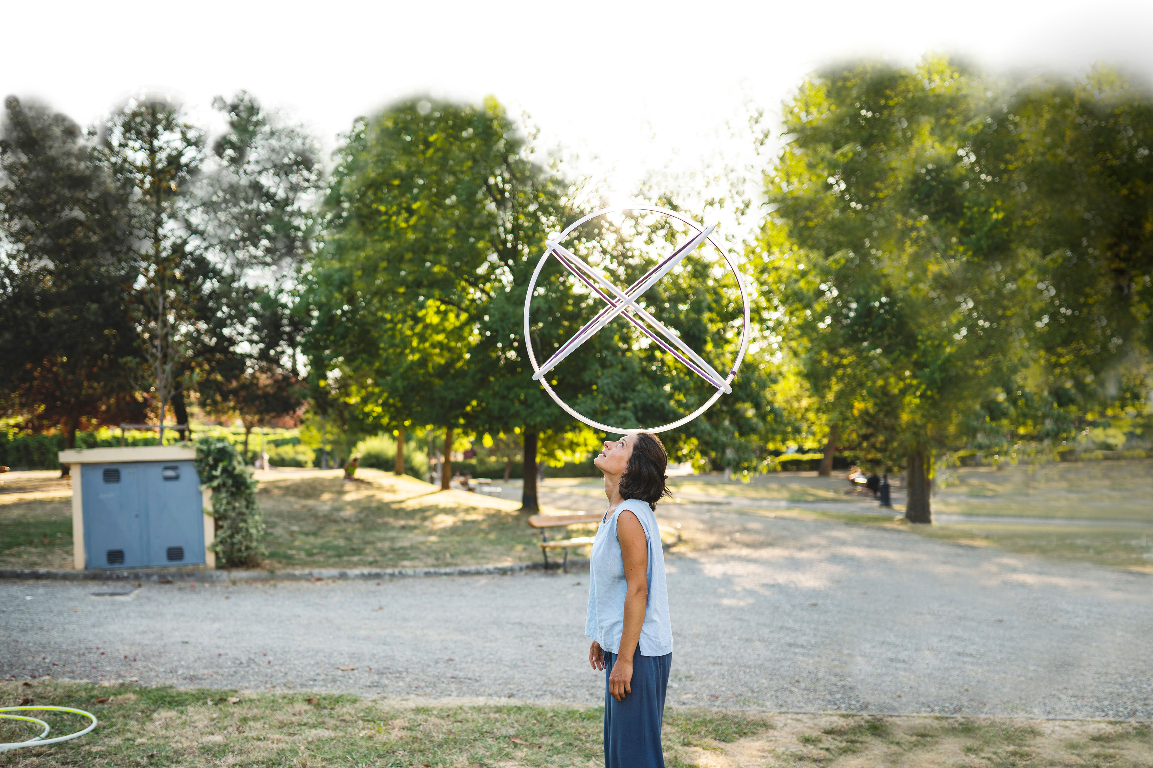 Woman balancing hula hoop on her head at the park