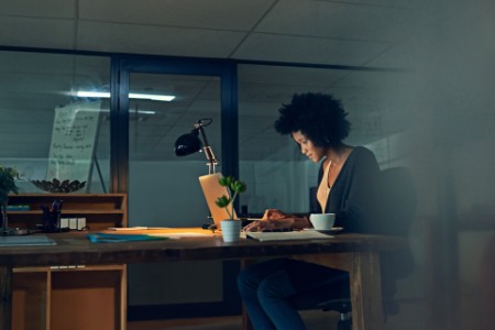 Young businesswoman working late on a laptop in an office