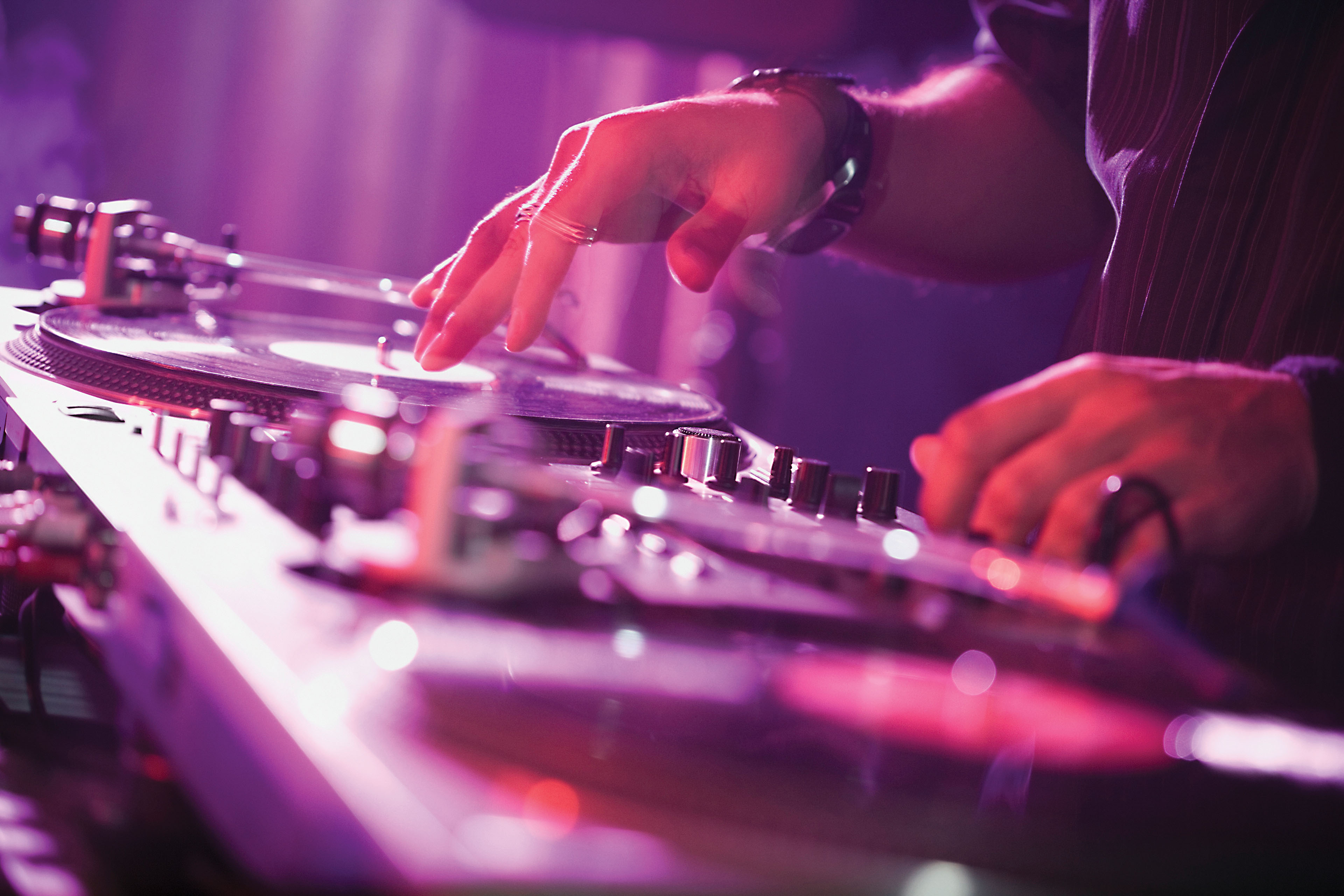Close up of a DJ on the decks in a nightclub