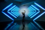 girl dancing in a studio with graphic patterns projected onto wall behind her