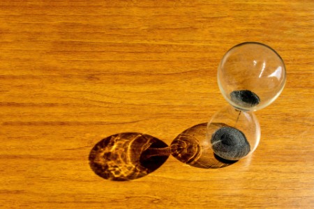 High Angle View of Hourglass On Wooden Table