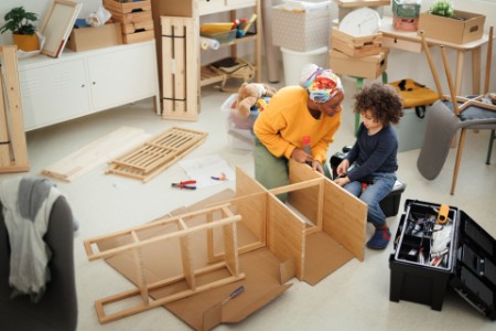 little boy helping his mother with furniture assembly
