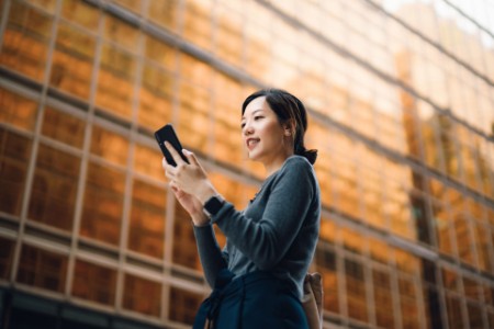 Low angle portrait of young asian businesswoman on smartphone