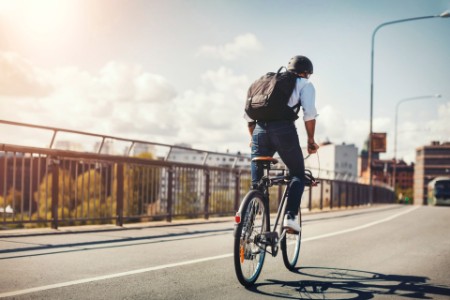Businessman riding bicycle on bridge