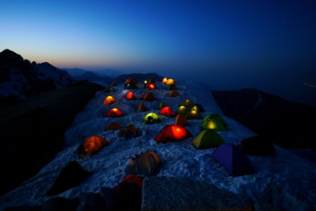 view of colorful tents at night on a mountain