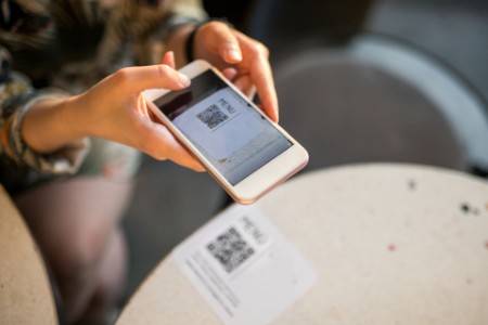 Mujer escaneando el código QR para el menú online
