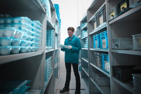 A photograph of a female worker in a storeroom.