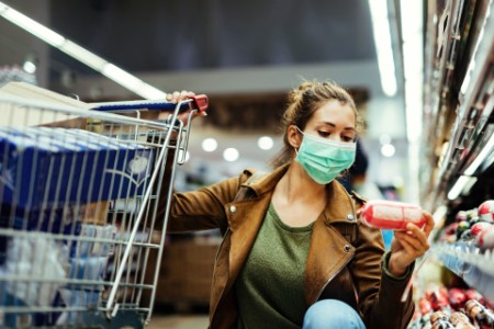 Woman buying groceries wearing face mask in the supermarket