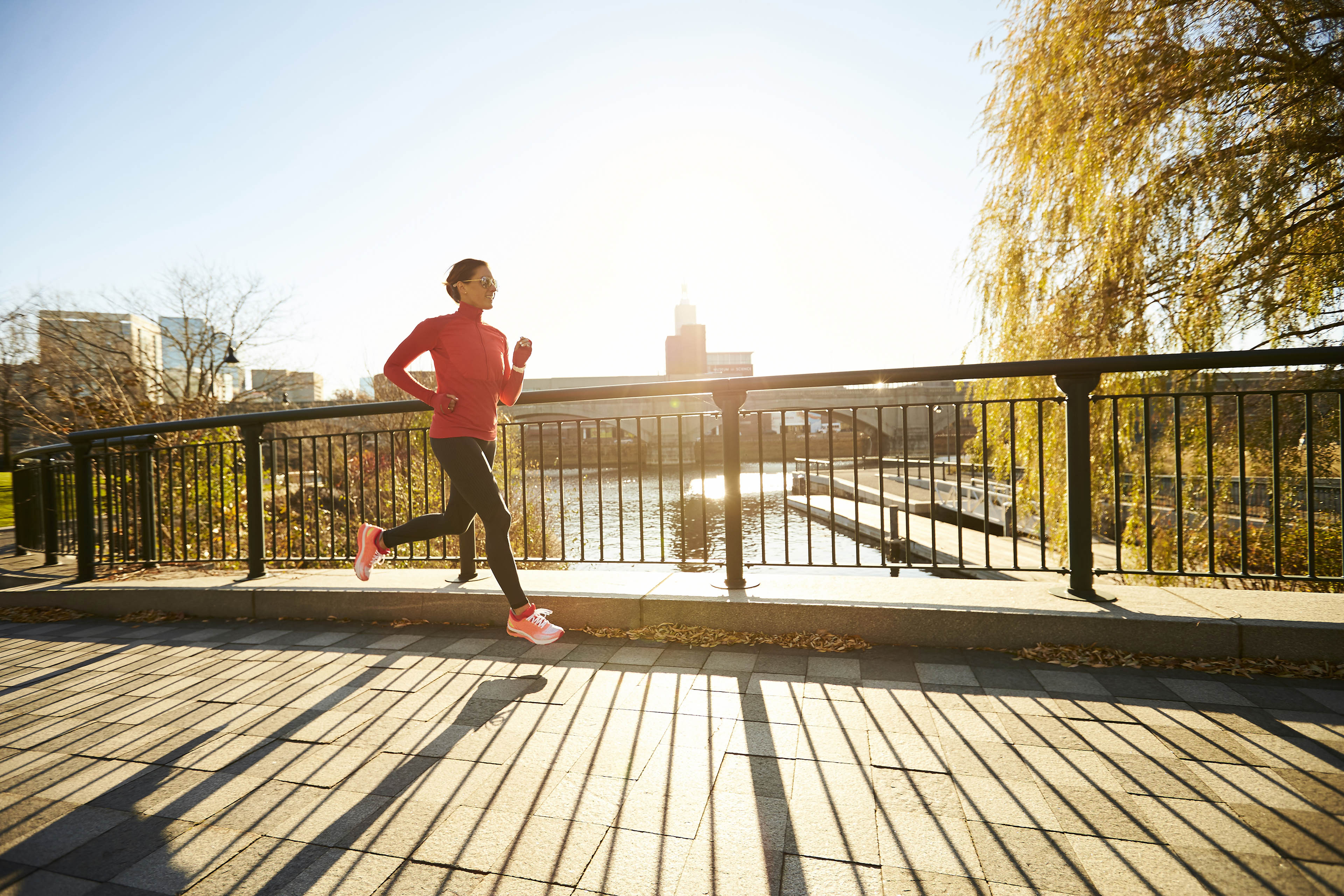 EY woman jogging over-bridge on sunny morning